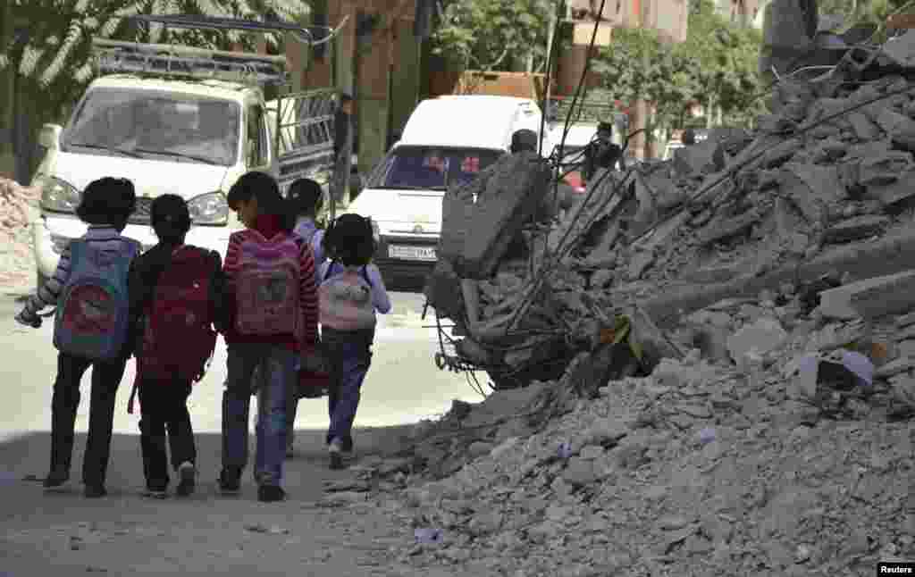 Children walk through damaged streets as they go to school in the Duma neighbourhood in Damascus, Sept. 29, 2013. 