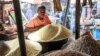 Chinedu Nwuzor waits for costumers while selling grains, legumes and flours in his stall at a market in the Obalende area of Lagos on December 18, 2023.