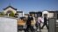 Workers of a funeral home company pull the coffin of a COVID-19 victim for burial at the cemetery near Cuneo, northwestern Italy, April 24, 2020.