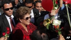 Unos 100 simpatizantes la acompañaron y le lanzaron pétalos rojos y amarillos cuando se bajó de su auto a saludarlos.