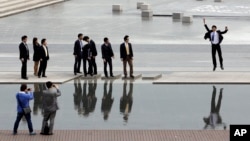 한국 서울의 직장인들이 점심 시간 동료들과 함께 거리에서 사진을 찍고 있다. (자료사진)