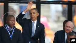 El intérprete sudafricano Thamsanqa Janjie (círculo) aparece confundido junto al presidente Barack Obama, en el homenaje a Nelson Mandela.