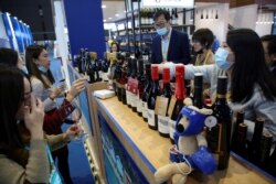 FILE - People taste wines from Australia at the Food and Agricultural Products exhibition at the third China International Import Expo (CIIE) in Shanghai, China, Nov. 5, 2020.