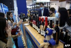 FILE - People taste wines from Australia at the Food and Agricultural Products exhibition at the third China International Import Expo (CIIE) in Shanghai, China, Nov. 5, 2020.