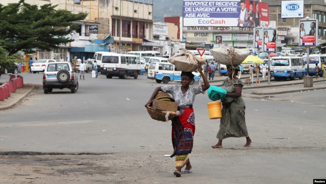 Des vendeurs portent les leurs produits, dans les rues de Bujumbura, le 3 février 2016.
