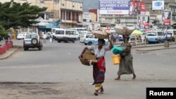 Des vendeurs portent les leurs produits, dans les rues de Bujumbura, le 3 février 2016.