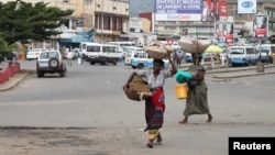 Des vendeurs portent les leurs produits, dans les rues de Bujumbura, le 3 février 2016.