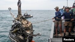 Anggota TNI AL menarik serpihan puing saat mencari sisa-sisa pesawat Sriwijaya Air penerbangan SJ 182 yang jatuh ke laut lepas pantai Jakarta, 11 Januari 2021. (Foto: Antara/M Risyal Hidayat via Reuters)