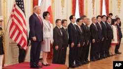 资料照片：在东京赤坂迎宾馆举行的欢迎仪式上，特朗普(左)在日本首相高市早苗(右)的陪同下检阅了仪仗队。(2025年10月28日)