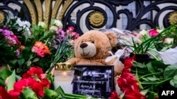 Cveće, sveća, plišani meda i poruka "Tugujemo sa vama" ispred ruske ambasade u Berlinu (Foto: John MACDOUGALL / AFP)