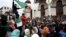 FILE - People carry national flags and banners during a protest calling on President Abdelaziz Bouteflika to quit, in Algiers, Algeria, March 26, 2019. 