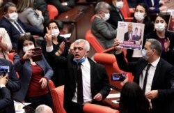 Omer Faruk Gergerlioglu, a human rights advocate and lawmaker from the People's Democratic Party, or HDP, center, reacts after the parliament stripped his parliamentary seat, in Ankara, Turkey, March 17, 2021.