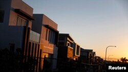 FILE - New million-dollar homes are pictured under construction at sunset in southern Sydney, Aug. 14, 2014. More wealthy Chinese are moving their money out of China to invest in Australia's property market.