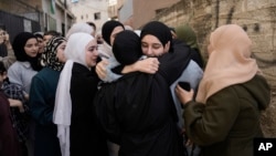 Dunya Shtayyeh, center, a former Palestinian prisoner who was released from an Israeli prison as part of a cease-fire deal between Israel and Hamas, is greeted by friends and family members in the West Bank village of Salem, Jan. 20, 2025.