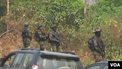 FILE - The military stands guard as government officials visit Lebialem, in southwest Cameroon, Sept. 15, 2018. Three village chiefs from Lebialem were murdered Feb. 13, 2021, by suspected rebels. 
