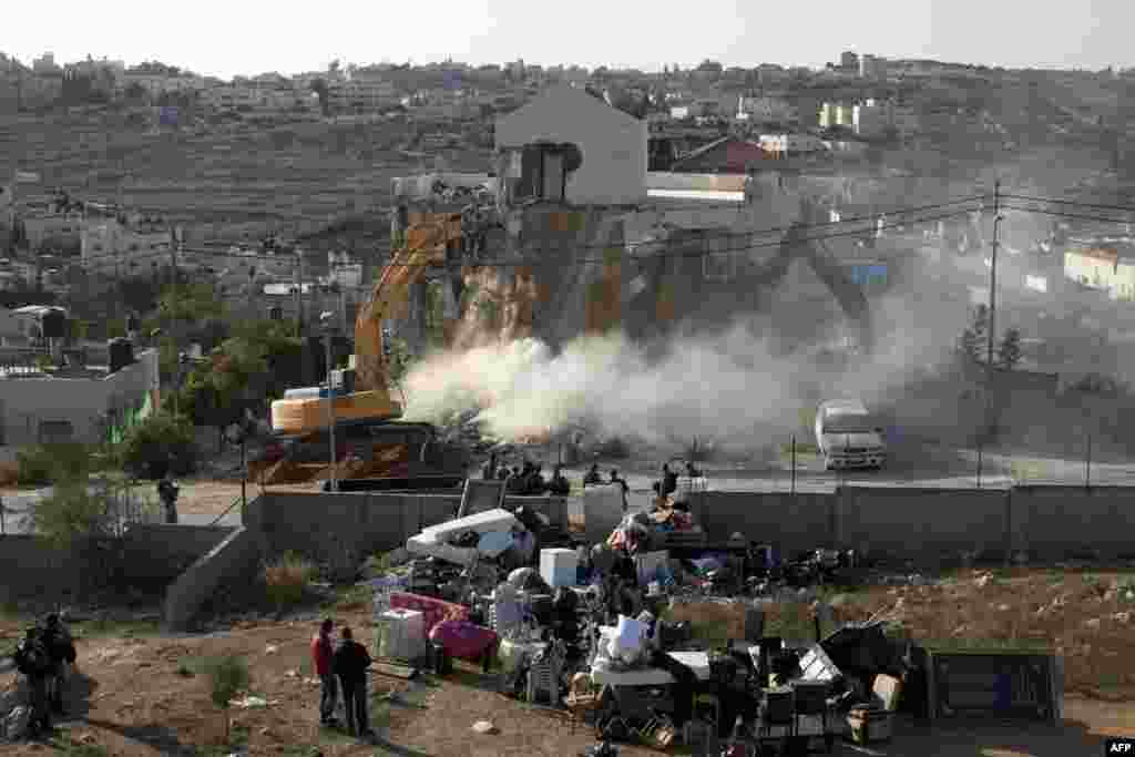 Seorang pekerja Israel menggunakan buldozer untuk menghancurkan rumah milik keluarga Palestina yang dibangun tanpa izin di distrik Beit Hanina, Yerusalem timur. 