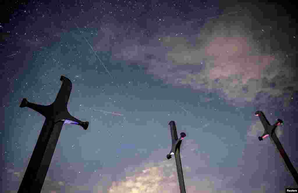 Meteors streak past stars in the night sky above the Battle of Didgori memorial complex during the annual Perseid meteor shower at Didgori, Georgia.