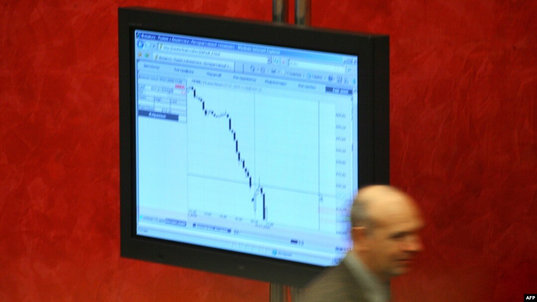 Seorang pialang Rusia melintas di depan sebuah monitor di bursa saham MICEX di Moskow (foto: dok).