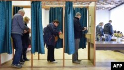People vote at a polling station in Ogre, Latvia, during general elections, Oct. 6, 2018.