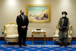 FILE - Then-U.S. Secretary of State Mike Pompeo meets with Mullah Abdul Ghani Baradar, head of the Taliban's peace negotiation team, amid talks between the Taliban and the Afghan government, in Doha, Qatar, Nov. 21, 2020.