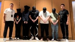 FILE - Myanmar police hand over five telecom and internet fraud suspects to Chinese police at Yangon International Airport in Yangon, Myanmar, Aug. 26, 2023. Sources tell VOA that scam operations in Myanmar are expanding south along the Thai border. (Xinhua News Agency via AP)