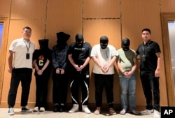 FILE - Myanmar police hand over five telecom and internet fraud suspects to Chinese police at Yangon International Airport in Yangon, Myanmar, on Aug. 26, 2023. (Xinhua News Agency via AP)