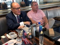 FILE - U.S. President Trump's personal lawyer Rudy Giuliani has coffee with Ukrainian-American businessman Lev Parnas at the Trump International Hotel in Washington, Sept. 20, 2019.