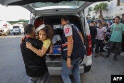 Tenaga medis melarikan anak-anak perempuan Palestina yang cedera akibat serangan Israel ke Rumah Sakit Al-Shifa di Kota Gaza, Minggu, 15 Oktober 2023. (Foto: Dawood NEMER/ AFP)