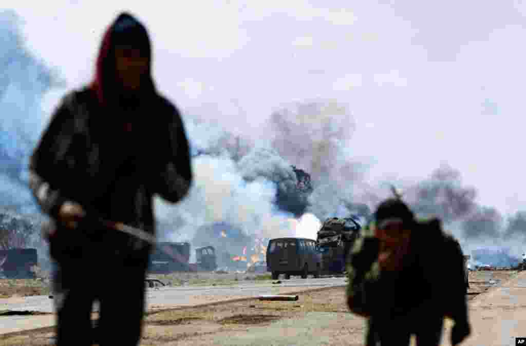 Rebel fighters run for cover on a road between Benghazi And Ajdabiya, after an air strike on March 20, 2011, by coalition leaders on forces loyal to Muammar Gadhafi. (Reuters/Goran Tomasevic)