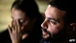 Omer (R) and Zemer Weiss, the son and daughter in-law of late Israeli hostage Yehudit Weiss, speak during an interview with AFP in their home in Moshav Olesh in central Israel, on November 17, 2023.