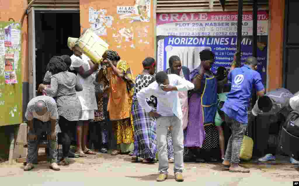 Ugandan shop traders and protesters recover from tear gas in Kampala, Uganda. Ugandan police fired bullets and tear gas to disperse a crowd of protesters demanding the release of jailed lawmaker, pop star, and government critic Kyagulanyi Ssentamu, whose stage name is Bobi Wine.