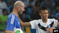 Neymar, à droite, et Zidane discutent lors d’un match amical contre la pauvreté initié par le PNUD, à Porto Alegre, Brésil, 19 décembre 2012