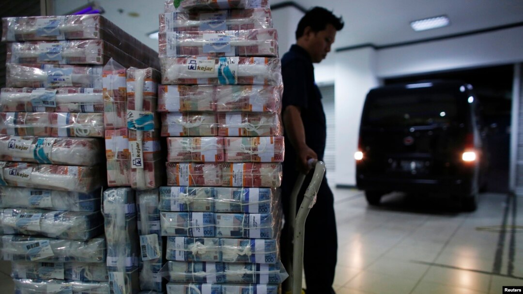 Seorang petugas menunggu untuk mengangkut uang rupiah ke kendaraan di kantor pusat Bank Mandiri, Jakarta (18/11). (Reuters/Darren Whiteside)