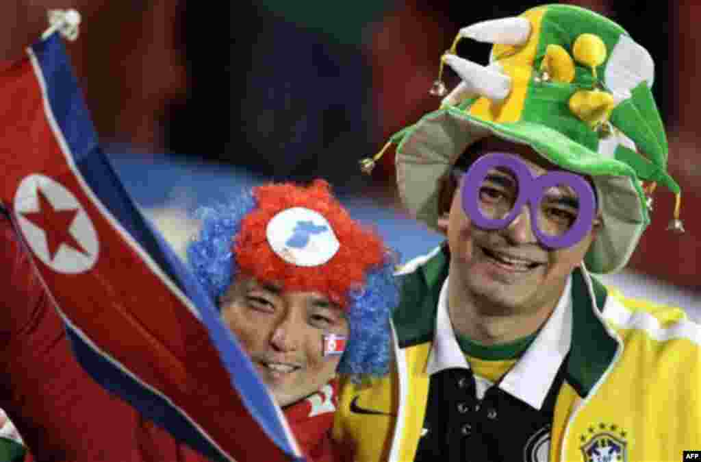 A North Korean, left, and a Brazilian fan wait for the World Cup group G soccer match between Brazil and North Korea at Ellis Park Stadium in Johannesburg, South Africa, Tuesday, June 15, 2010. (AP Photo/Ivan Sekretarev)