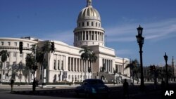 Polisi berjaga di gedung National Capitol di Havana, Cuba, Senin, 12 Juli 2021. (Foto: AP Photo/Eliana Aponte)