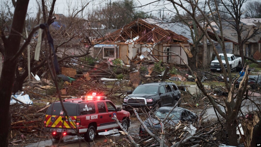 An emergency vehicle drives through a neighborhood in Rowlett, Texas, Dec. 27, 2015, the morning after it was struck by a tornado. 