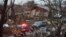 An emergency vehicle drives through a neighborhood in Rowlett, Texas, Dec. 27, 2015, the morning after it was struck by a tornado. 
