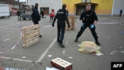 French municipal police officers collect evidence at the site of a bladed weapon attack where a man is suspected of killing one person and wounding two municipal police officers in Mulhouse, eastern France, Feb. 22, 2025. 