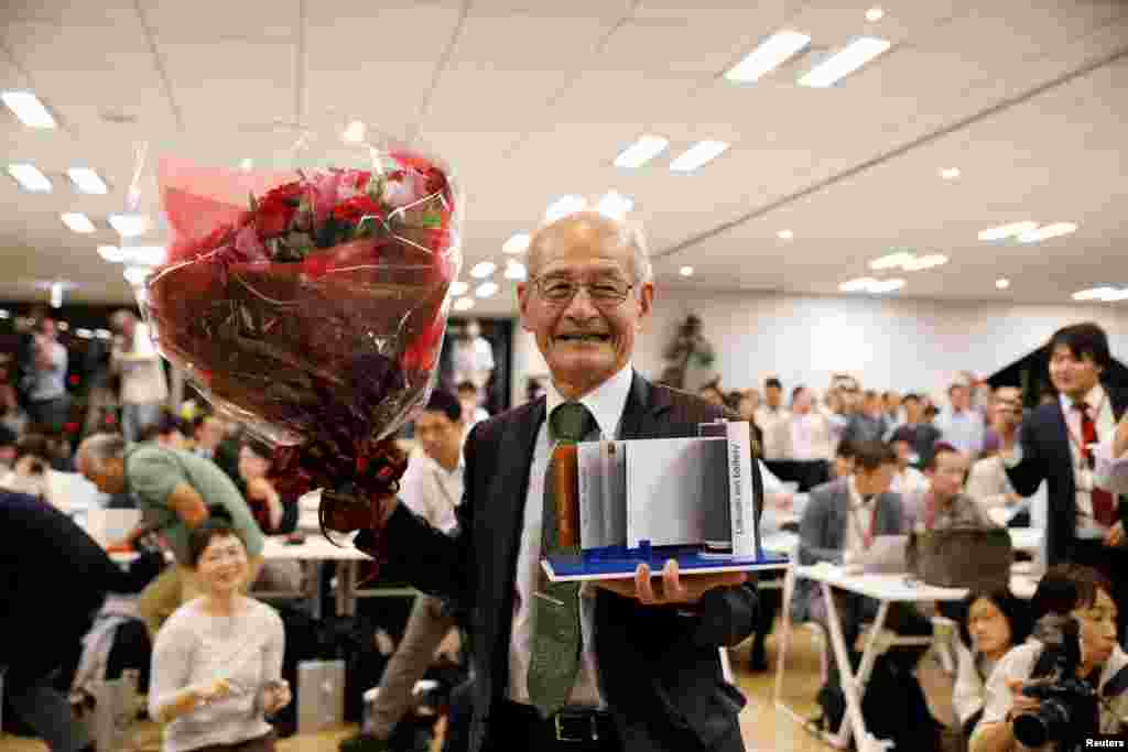 Asahi Kasei honorary fellow Akira Yoshino, 2019 Nobel Prize in Chemistry winner, holds a mock of lithium-ion battery and a flower bouquet during a news conference in Tokyo, Japan.