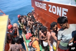 Para pengungsi Rohingya menaiki kapal SAR setelah diselamatkan dari kapal mereka yang terbalik di Aceh Barat, Kamis, 21 Maret 202. (Foto: Reza Saifullah/AP Photo)