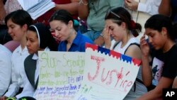 People gather at Saint Mark Catholic Church for a solidarity-with-migrants vigil, June 21, 2018, in El Paso, Texas. President Donald Trump's order ending the policy of separating immigrant families at the border leaves a host of unanswered questions, including what happens to the more than 2,300 children already taken from their parents.