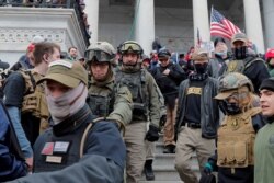 FILE - Jessica Watkins, second from left, and Donovan Crowl, center, both from Ohio, march down the east front steps of the U.S. Capitol with the Oath Keepers militia group among supporters of President Donald Trump in Washington, Jan. 6, 2021.