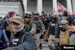 FILE - Jessica Watkins, second from left, and Donovan Crowl, center, both from Ohio, march down the east front steps of the U.S. Capitol with the Oath Keepers militia group among supporters of President Donald Trump in Washington, Jan. 6, 2021.