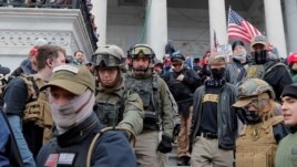 FILE - Jessica Watkins, second from left, and Donovan Crowl, center, both from Ohio, march down the east front steps of the U.S. Capitol with the Oath Keepers militia group among supporters of President Donald Trump in Washington, Jan. 6, 2021.
