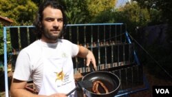 Zander Van Manen with sausages he cooked using heat from the sun. (Darren Taylor for VOA) 