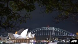 Jembatan Pelabuhan Sydney dan Gedung Opera sebelum gelap gulita karena lampu dimatikan untuk mengikuti kampanye lingkungan hidup Earth Hour, 24 Maret 2018.