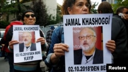 Para aktivis HAM membawa foto jurnalis Jamal Khashoggi yang masih "hilang", saat melakukan protes di depan Konsulat Saudi di Istanbul, Turki (9/10). 