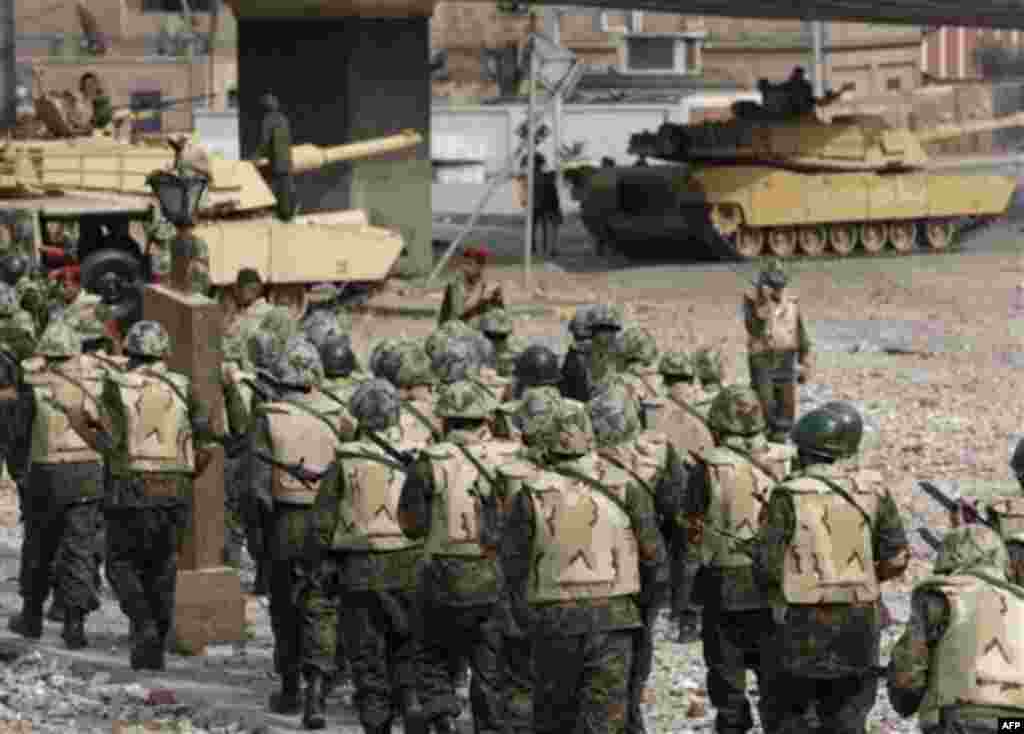 Soldiers take position just outside Cairo's main square, Egypt, Thursday, Feb. 3, 2011. Egypt's prime minister apologized for the attack by regime supporters on anti-government protesters in central Cairo, vowing to investigate who was behind it. The prot