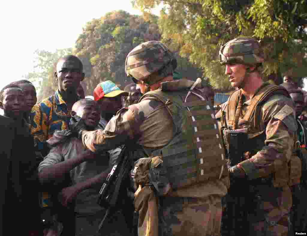 French military personnel try to control supporters who are asking them to disarm fighting gangs, near the airport in Bangui, Central African Republic. France appealed to European partners for assistance in quelling months of religious violence in its former colony.