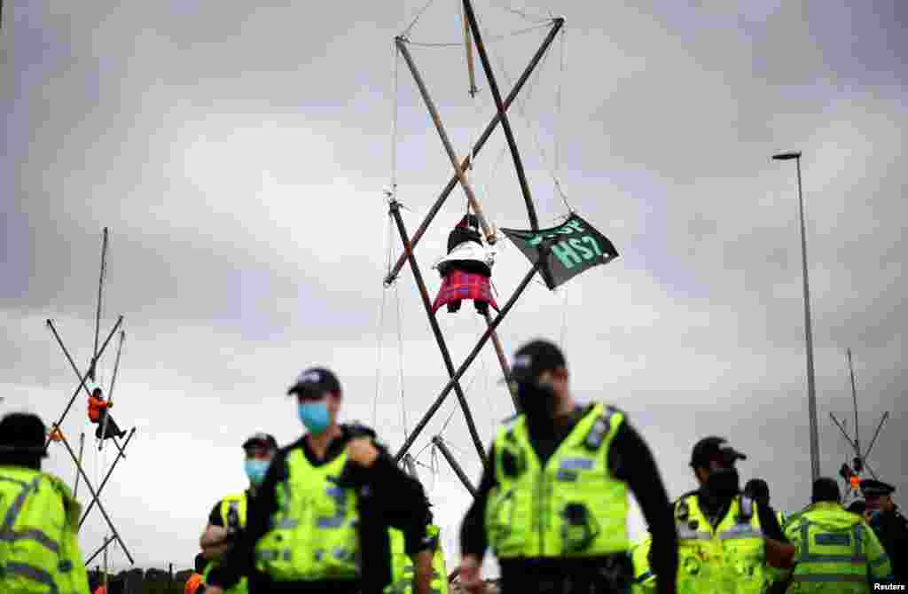 Extinction Rebellion activists are attached to structures they have built as they protest at the HS2 high-speed railway building site in Denham, Britain.